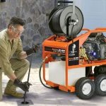 Plumber using hydro-jetting equipment for drain cleaning, emphasizing professional plumbing services by Chris Wilson Plumbing & Heating Repairs Inc.