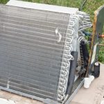 Cooling unit with metallic coils on concrete, supporting HVAC services from Chris Wilson Plumbing & Heating Repairs Inc.