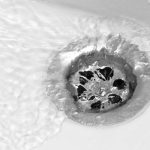 Drain with water flowing, illustrating the importance of professional drain cleaning services for preventing blockages and ensuring proper drainage.